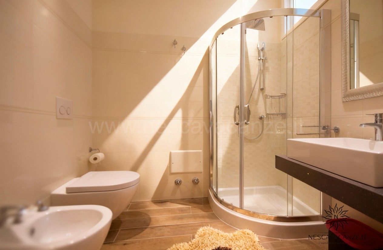 Casa Dune - bagno con doccia angolare in vetro, WC, bidet e lavabo integrato, pavimenti in legno