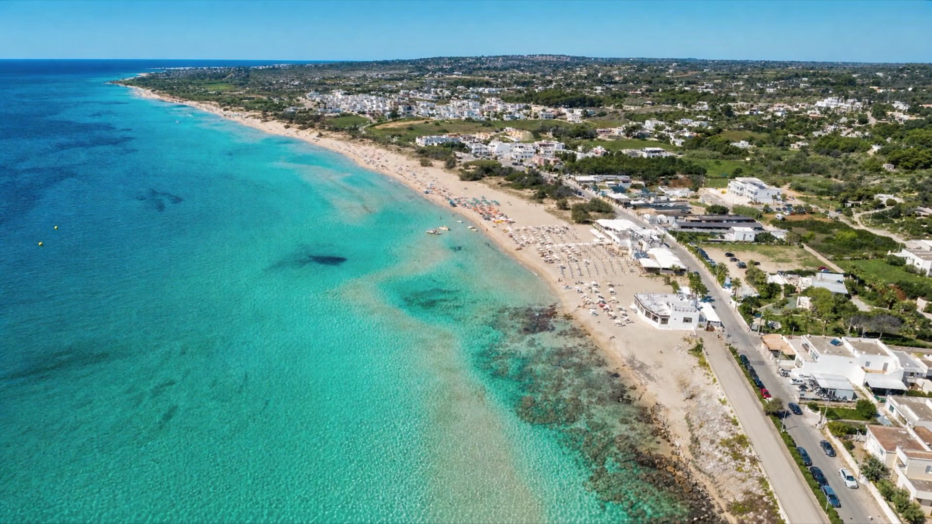 La lunga spiaggia di sabbia bianca di Pescoluse e il mare turchese visti dall'alto