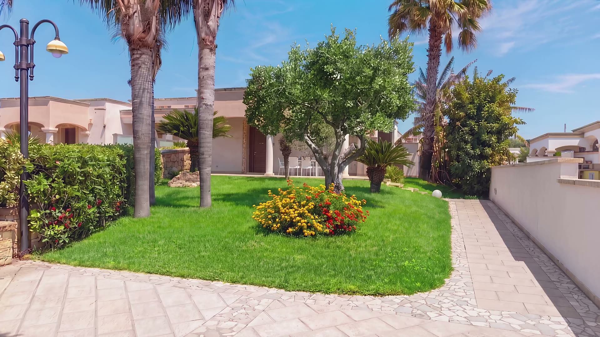Il giardino di Casa Pescoluse 8: il prato, le palme, l’ulivo e la lantana fiorita