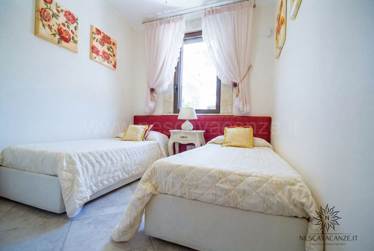 Casa Pescoluse 7 - cameretta con due letti singoli, testiera rossa e quadri floreali