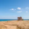 La torre di Torre Guaceto tra le dune e il mare blu della riserva