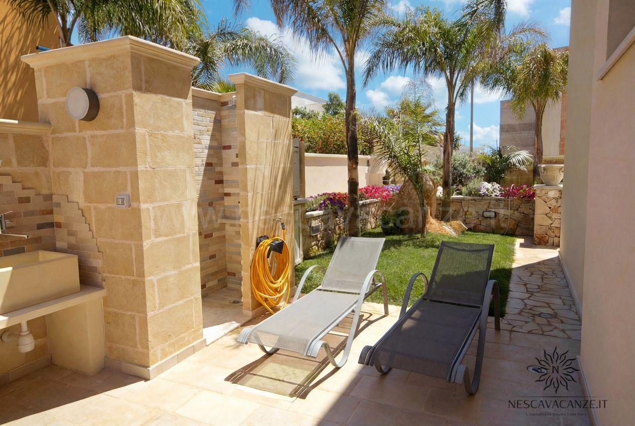 Casa Salento - doccia esterna in pietra con lettini prendisole sul patio e giardino con palme