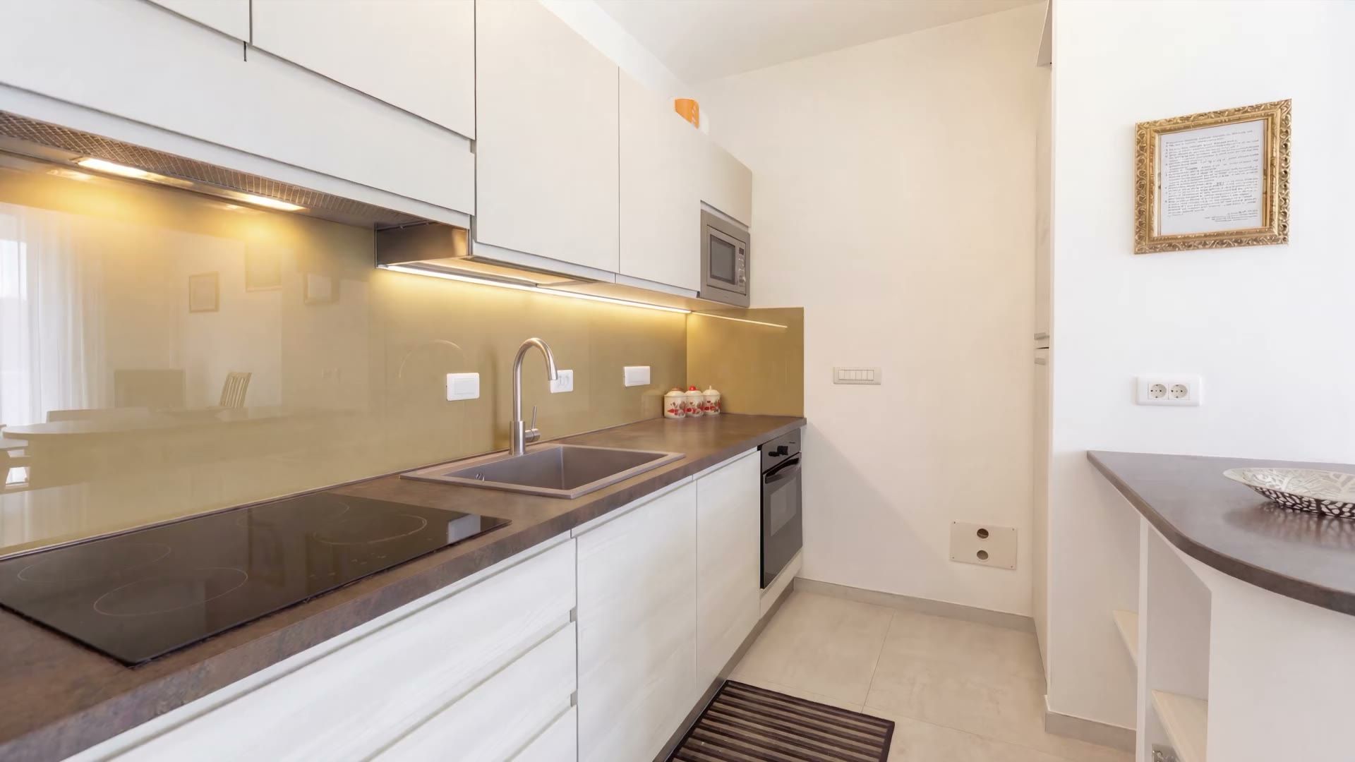 L’angolo cottura di Casa Pescoluse 3 con il piano a induzione, il lavello, il forno e il microonde