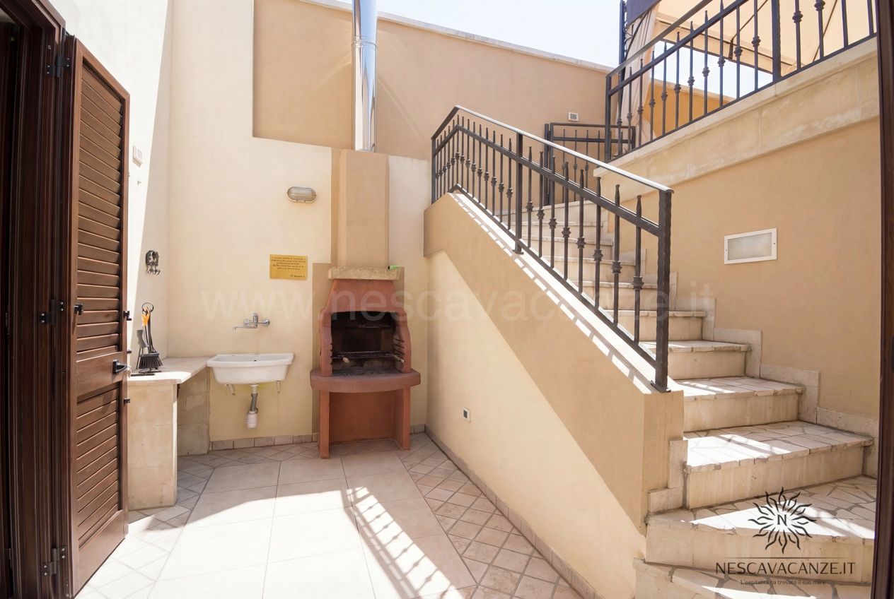 Casa Pescoluse 9 - corte esterna con barbecue in muratura, lavabo e scala in pietra con ringhiera