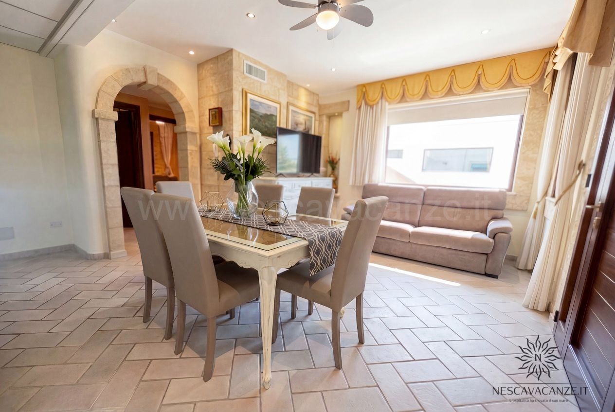 Casa Pescoluse 4 - soggiorno con tavolo da pranzo, sedie beige, divano, TV e ampia finestra luminosa