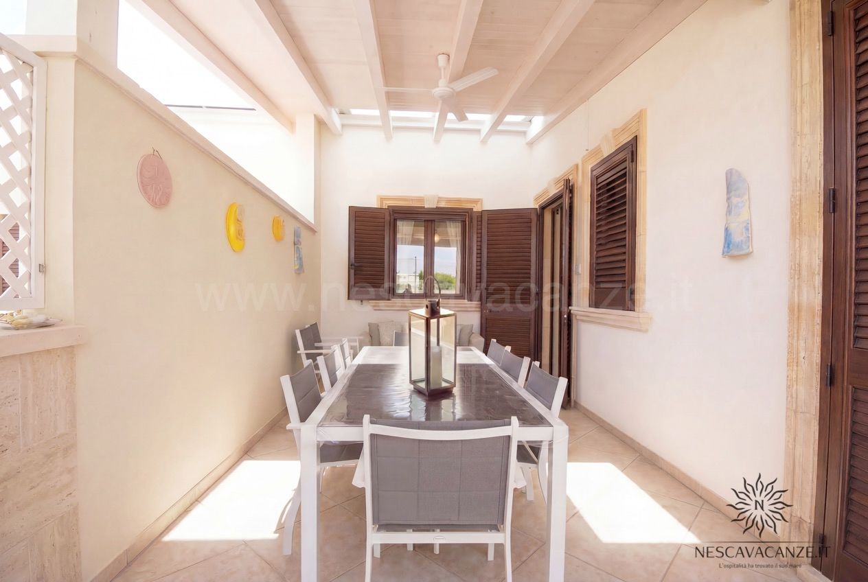 Casa Pescoluse 9 - veranda coperta con tavolo bianco, sedie grigie e ventilatore a soffitto