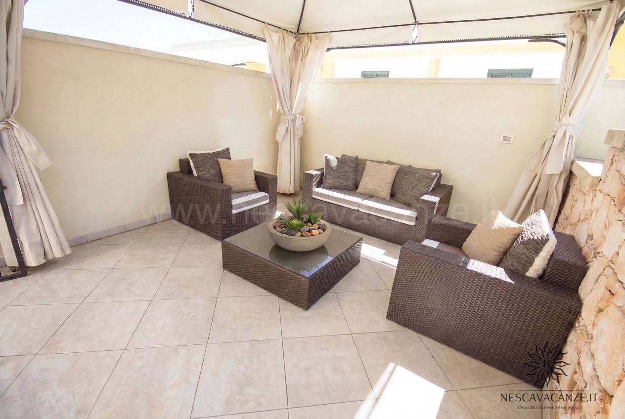 Casa Pescoluse 9 - terrazza lounge con divani in rattan marrone, gazebo e tavolino
