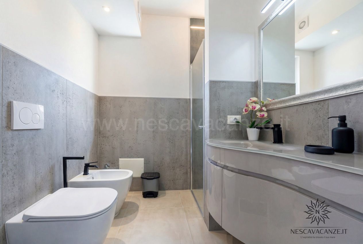 Casa Pescoluse 1 - bagno con piastrelle grigie, doccia, bidet, wc e lavabo