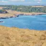 La Baia delle Orte, con la scogliera bassa e il mare blu sotto la macchia