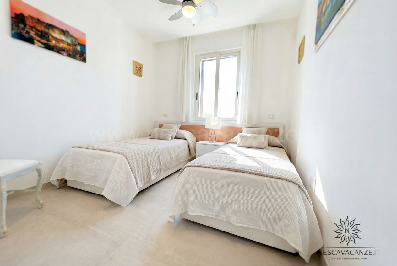 Casa Pescoluse 1 - cameretta con due letti singoli, finestra e quadri alle pareti