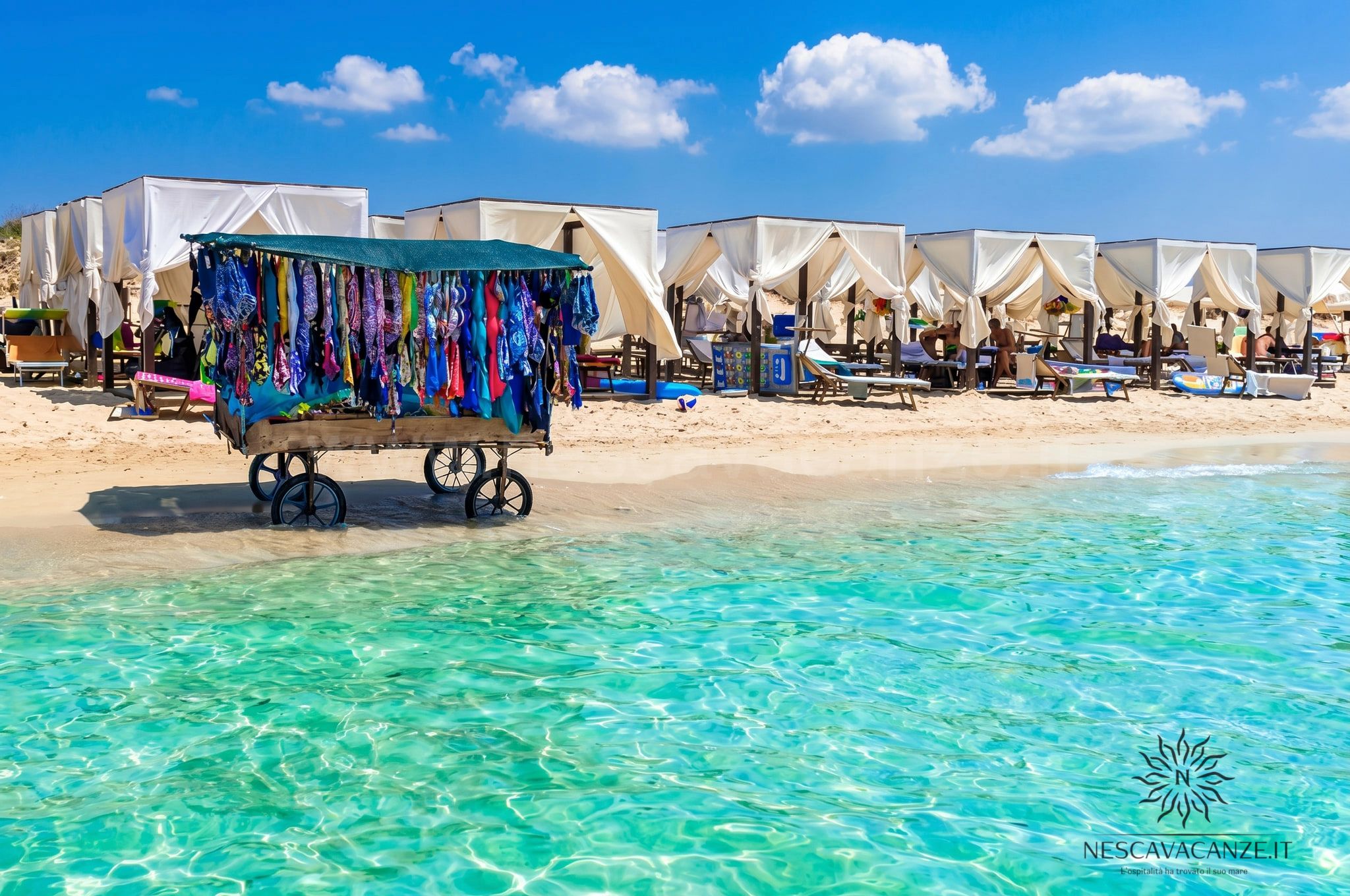 Spiaggia di Pescoluse con gazebo bianchi sul mare turchese