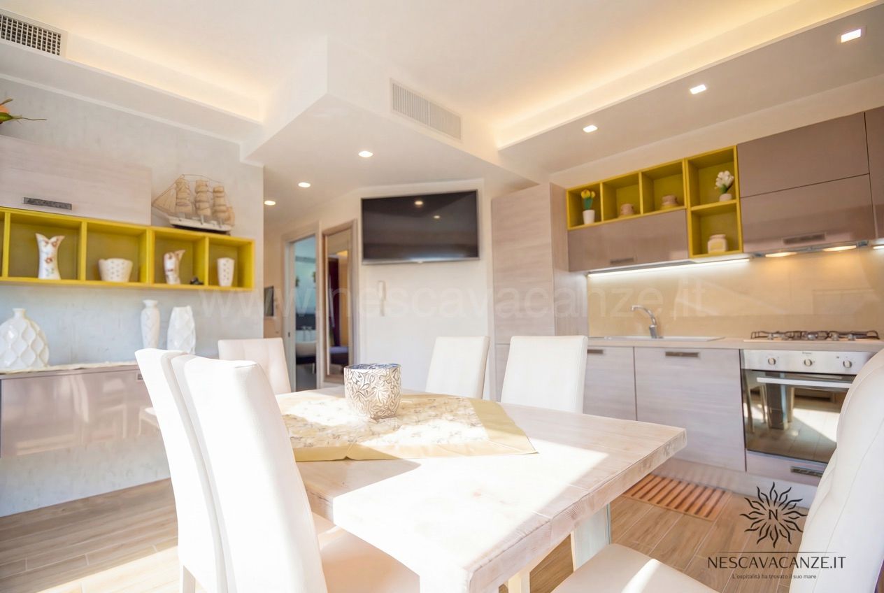 Casa Giglio - soggiorno open space con cucina, tavolo da pranzo, TV e mensole gialle