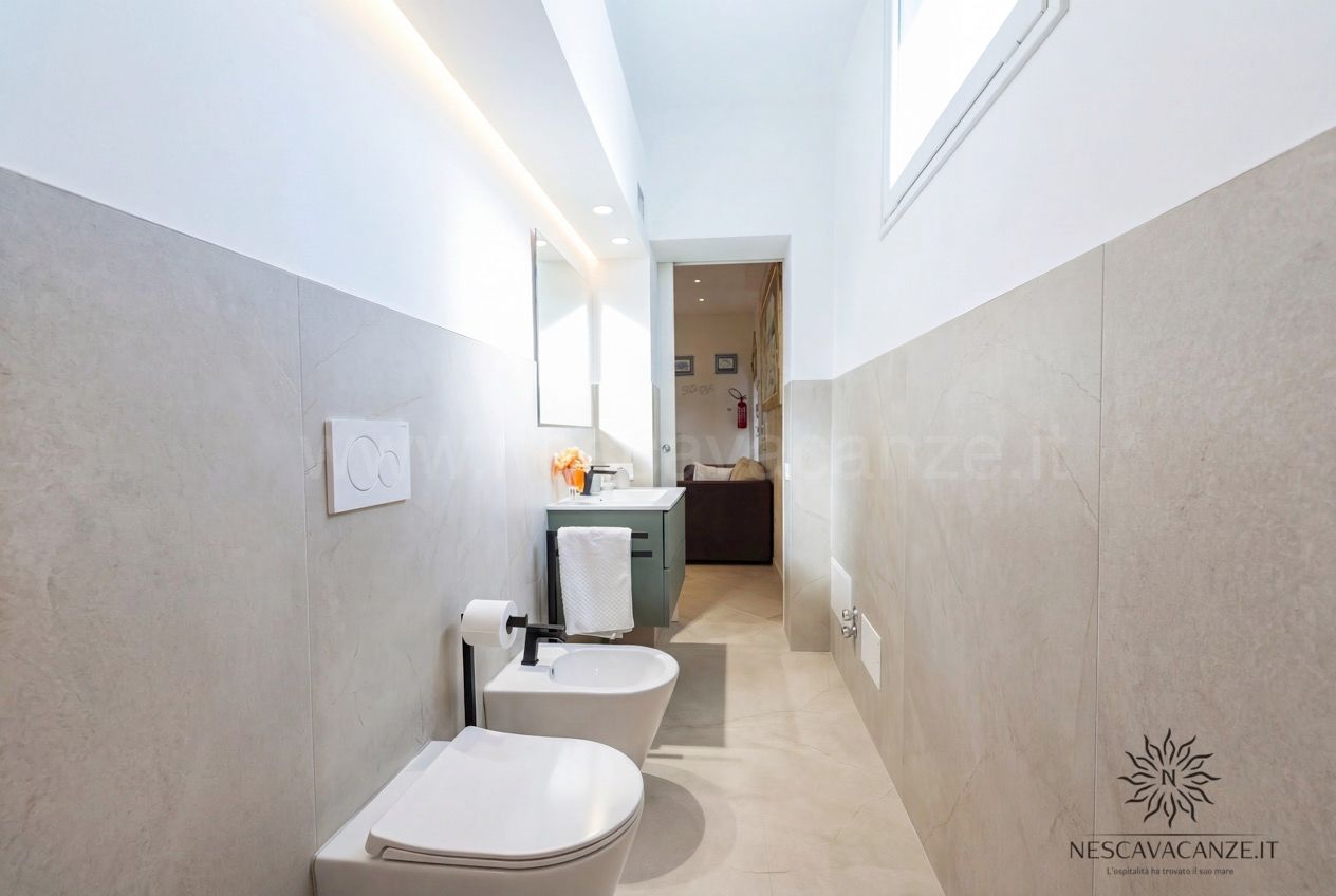 Casa Pescoluse 8 - Bagno moderno effetto marmo con wc, bidet, mobile lavabo verde e specchio