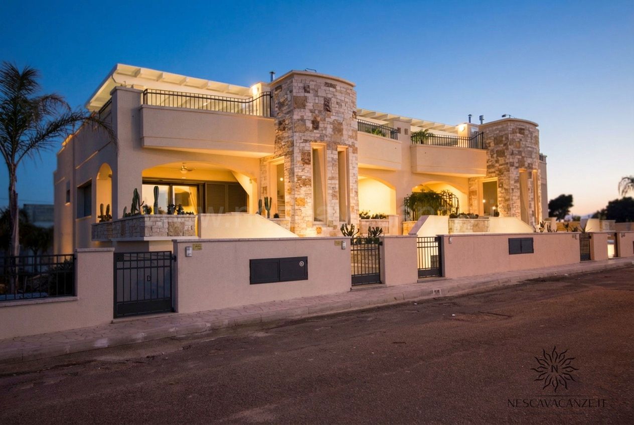 Casa Giglio - esterno della villa in pietra illuminata al tramonto, vista dalla strada