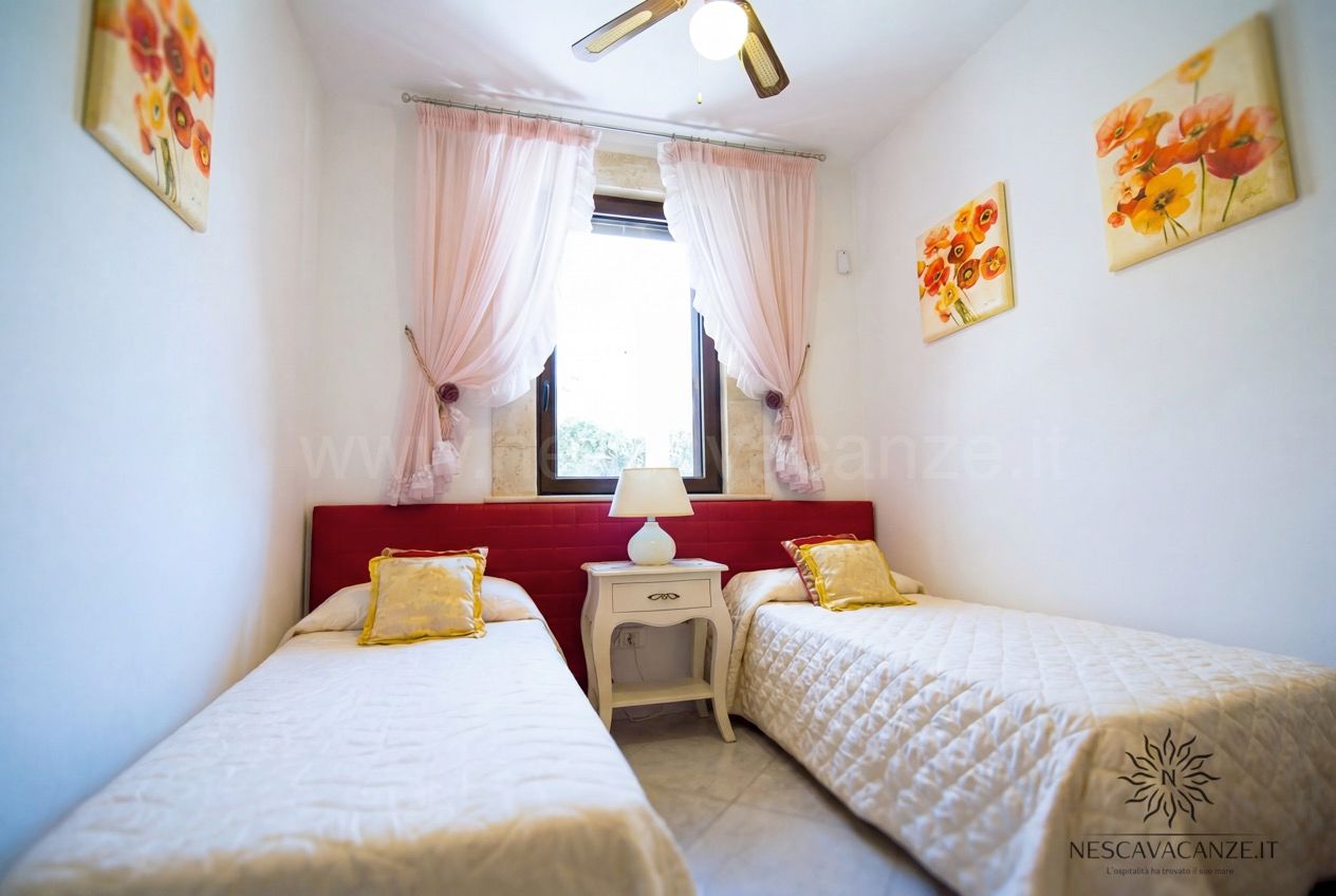 Casa Pescoluse 7 - cameretta con due letti singoli, testiera rossa, ventilatore e dipinti di papaveri