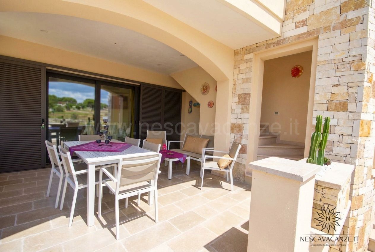 Casa Giglio - veranda con tavolo, divano e scala in pietra, vista sulla campagna
