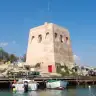 La torre di San Foca sul porticciolo, con le barche ormeggiate