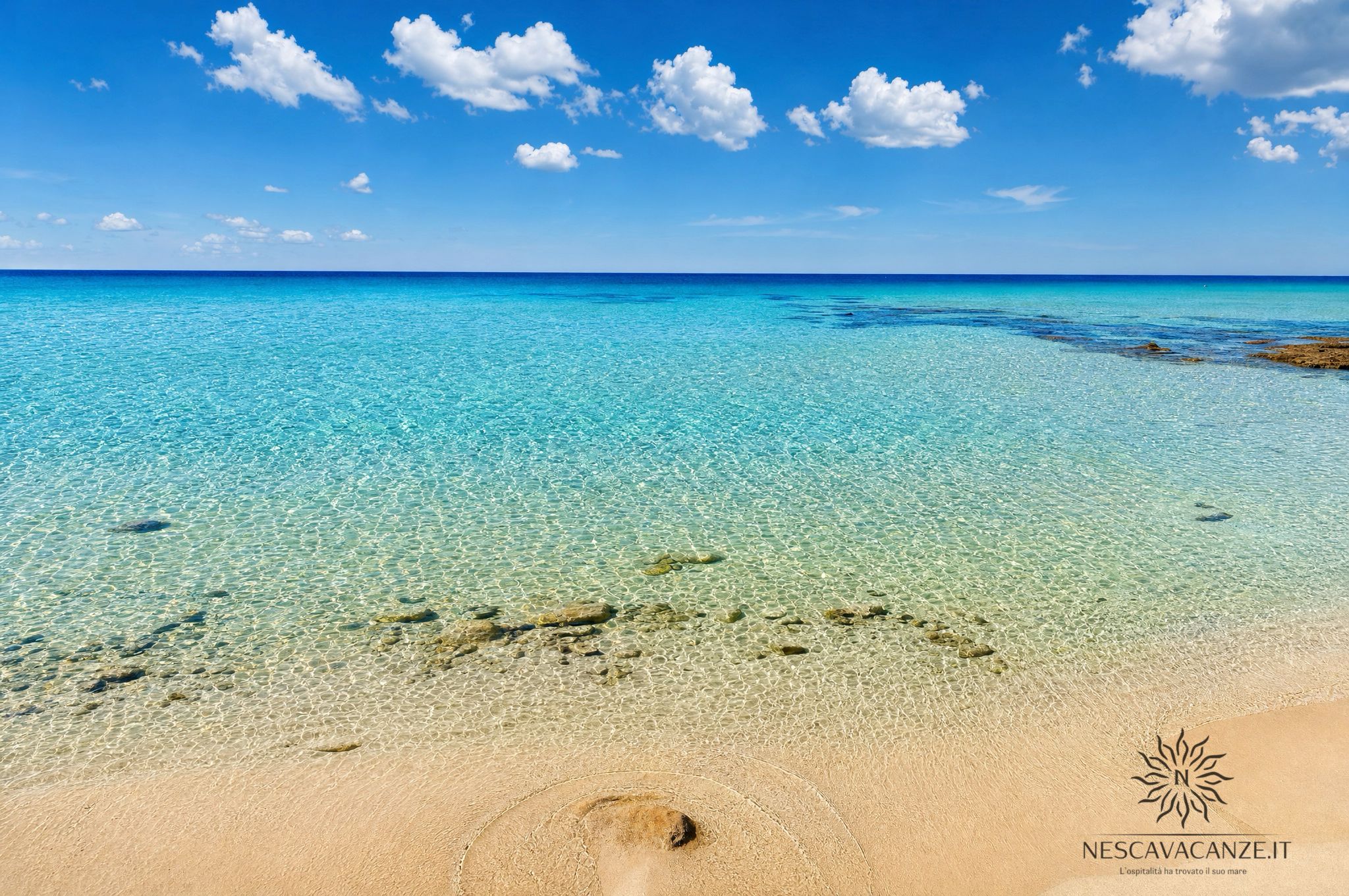 Pescoluse - spiaggia sabbiosa con acqua del mare trasparente e roccia affiorante