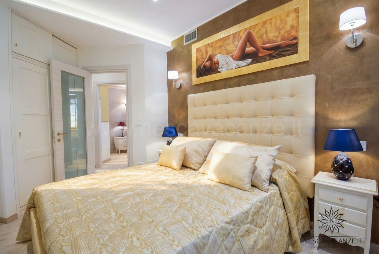 Casa Salento - camera matrimoniale con letto dorato, testiera capitonné e quadro sopra il letto