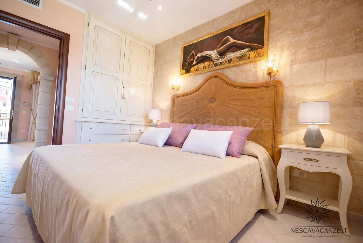 Casa Pescoluse 4 - camera matrimoniale con armadio bianco, dipinto, comodino e abat-jour