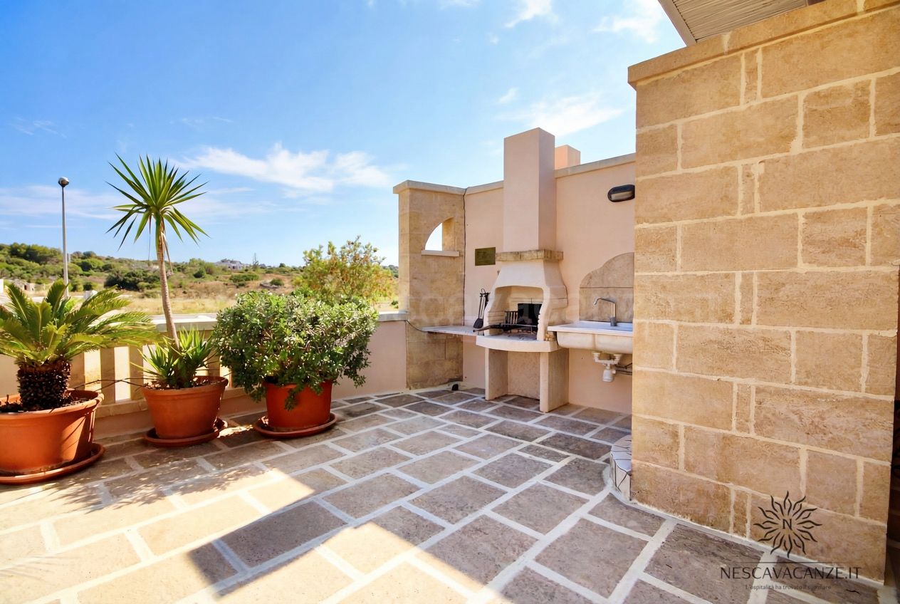 Casa Pescoluse 4 - terrazza con barbecue e lavabo in pietra, piante in vaso e vista campagna