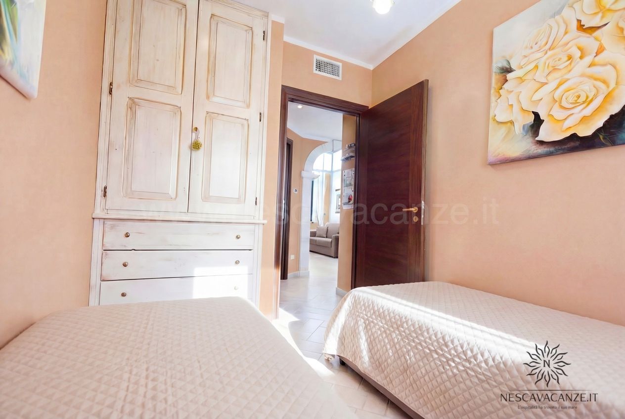 Casa Pescoluse 4 - camera doppia con armadio bianco anticato, quadro di rose e vista sul soggiorno