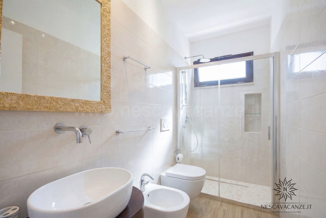 Casa Giglio - bagno con doccia box in vetro, lavabo ovale, bidet, wc e specchio dorato