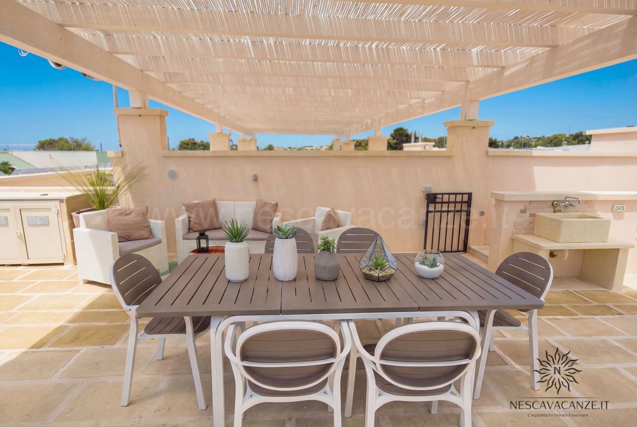 Casa Giglio - terrazzo attico con pergolato, tavolo, divani in rattan e lavabo in pietra