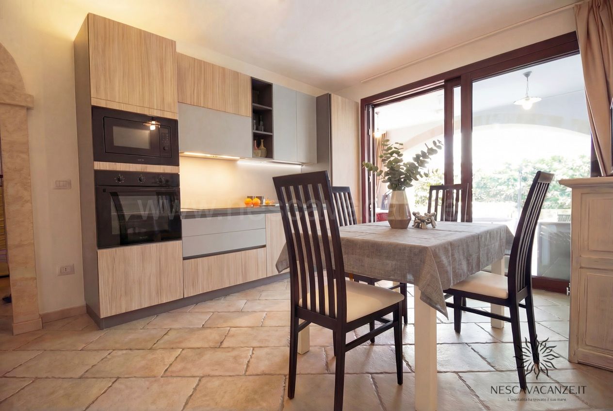 Casa Pescoluse 6 - cucina moderna in legno e grigio con forno, microonde e tavolo da pranzo