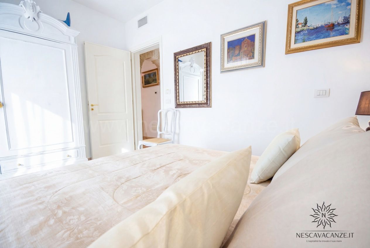 Casa Pescoluse 9 - camera matrimoniale luminosa con armadio bianco, specchio e quadri