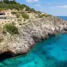 La baia del Ciolo vista dal ponte: acqua turchese, la grotta e le pareti di roccia