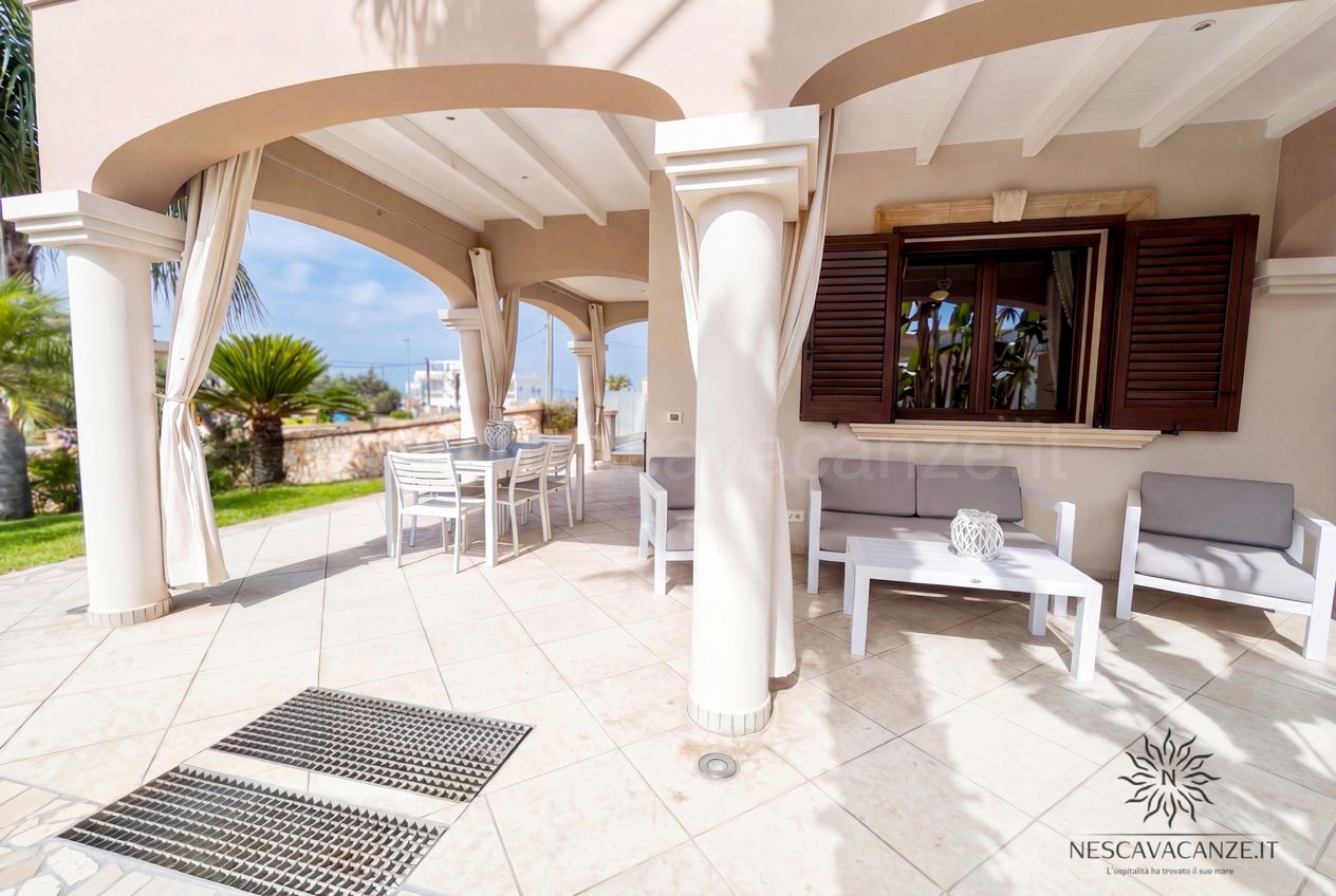 Casa Pescoluse 8 - Ampia veranda con salottino, tavolo da pranzo, divani bianchi e persiane in legno