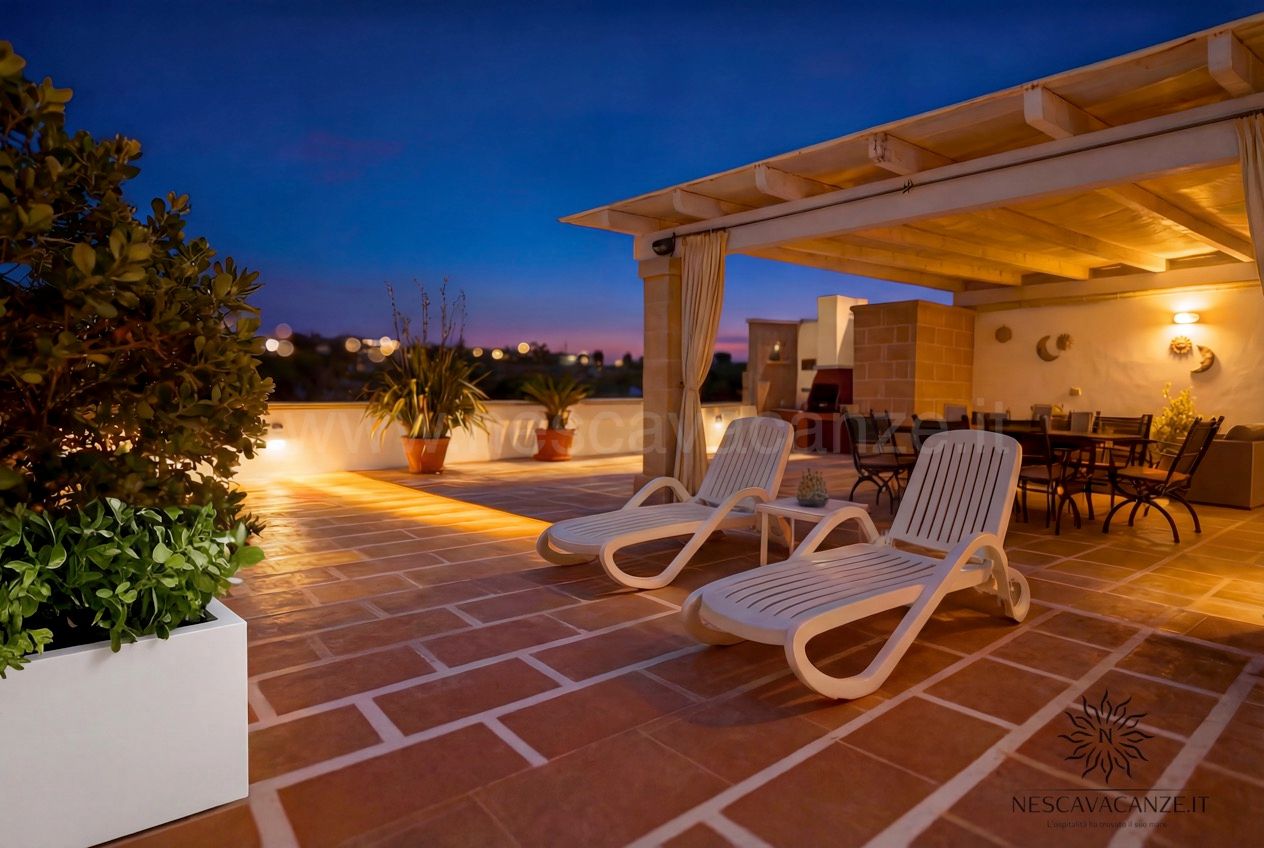 Casa Pescoluse 4 - terrazza al tramonto con lettini prendisole, pergolato illuminato e vista città