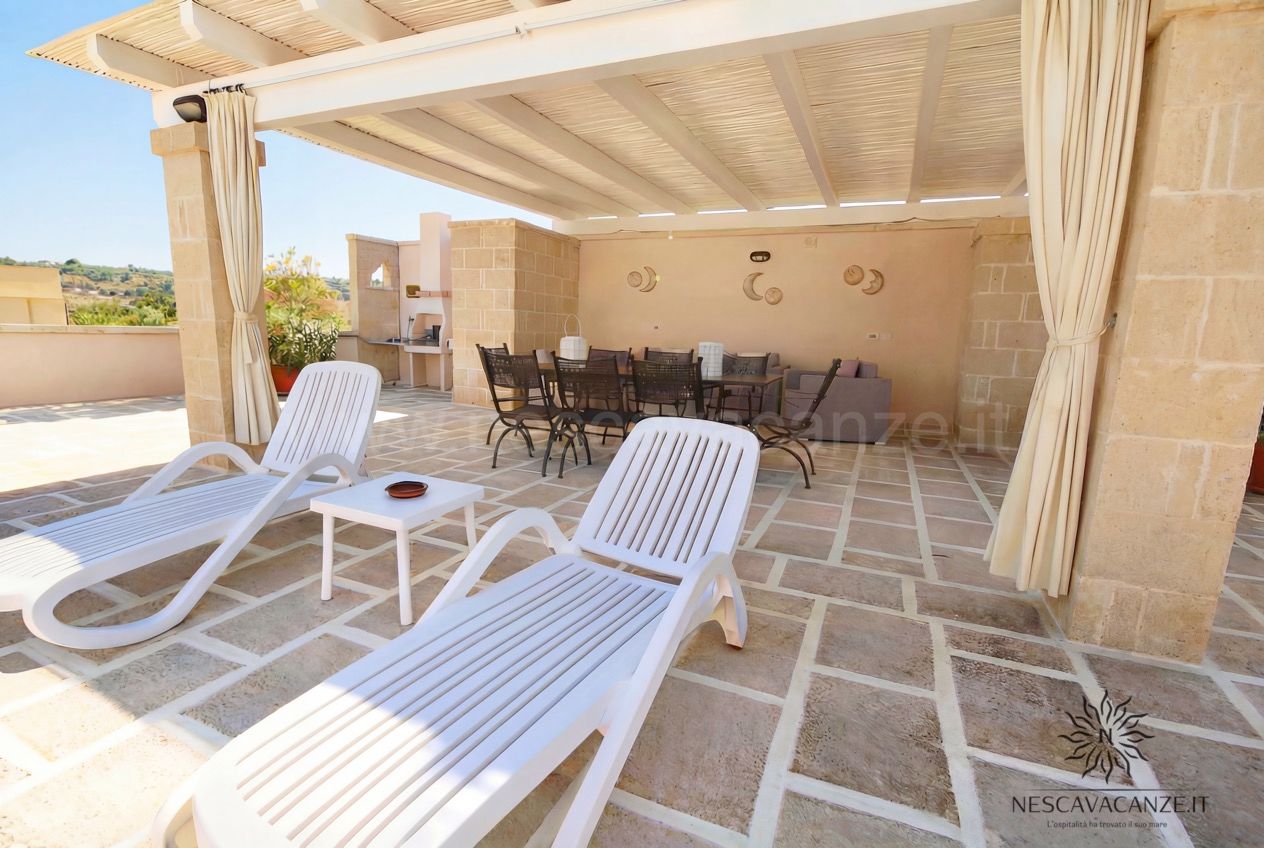 Casa Pescoluse 4 - terrazza con lettini prendisole, pergolato, zona pranzo in ferro e divano