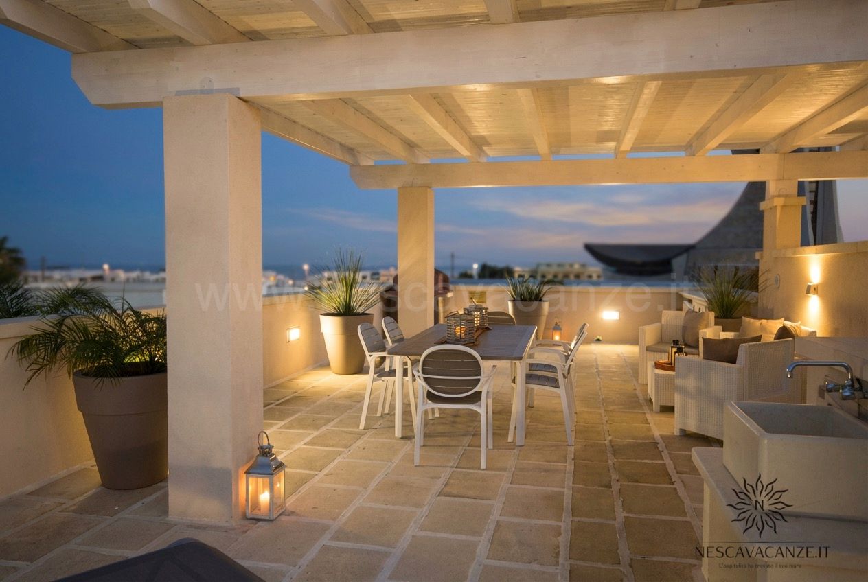 Casa Giglio - terrazzo con pergolato illuminato di sera, tavolo, divani e vista panoramica