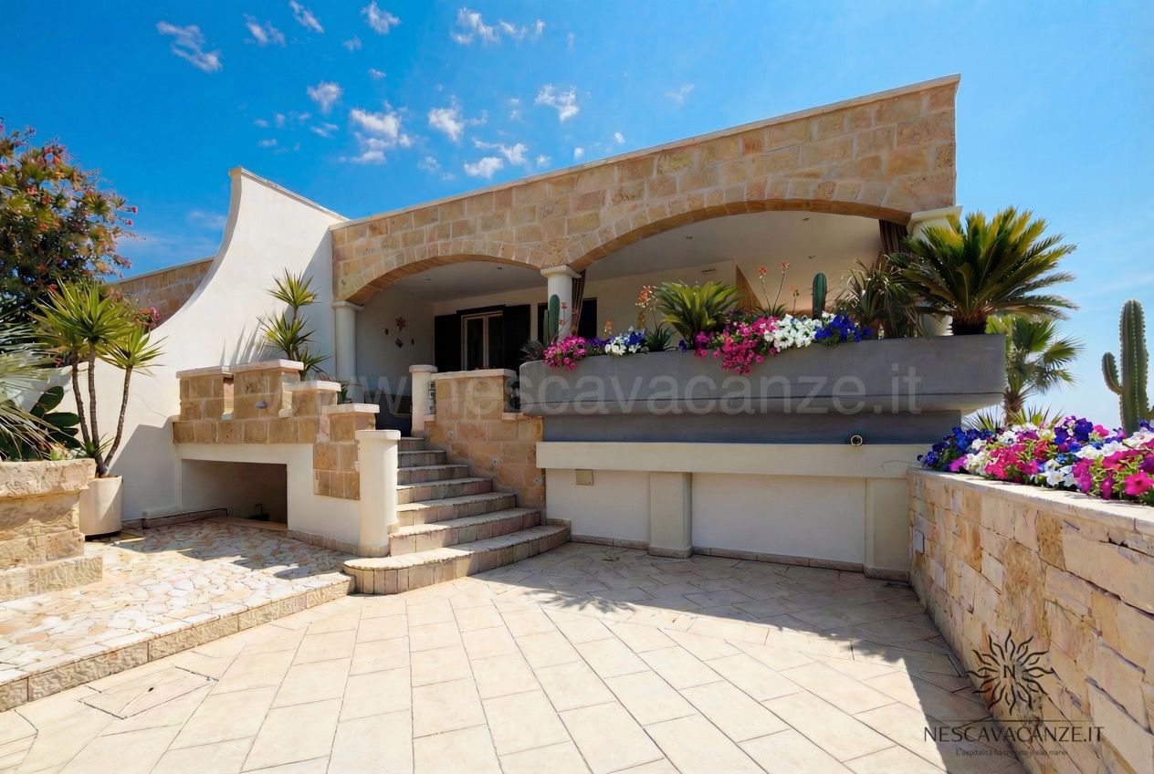 Casa Pescoluse 1 - cortile pavimentato con facciata ad archi, fioriere e scala in pietra