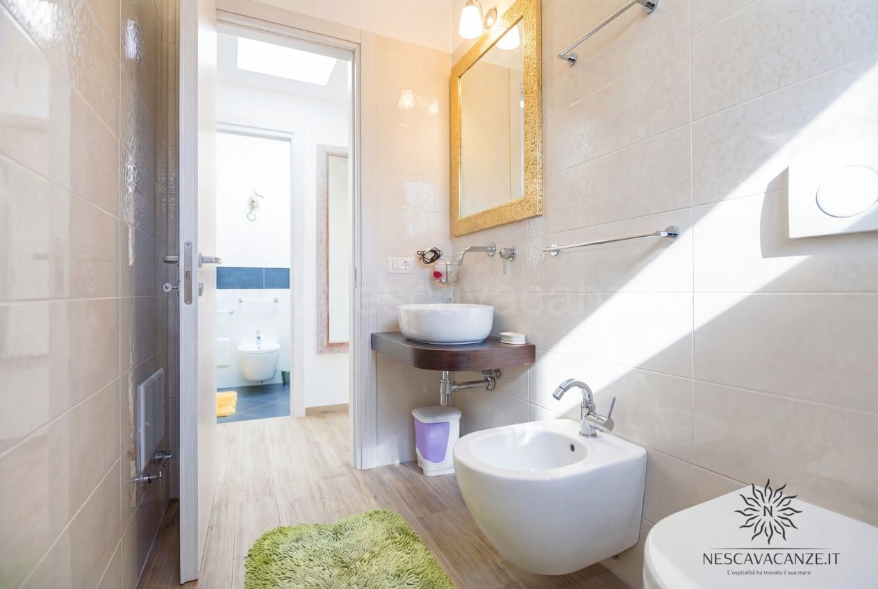 Casa Giglio - bagno stretto con lavabo, specchio dorato, bidet, wc e vista sulla stanza