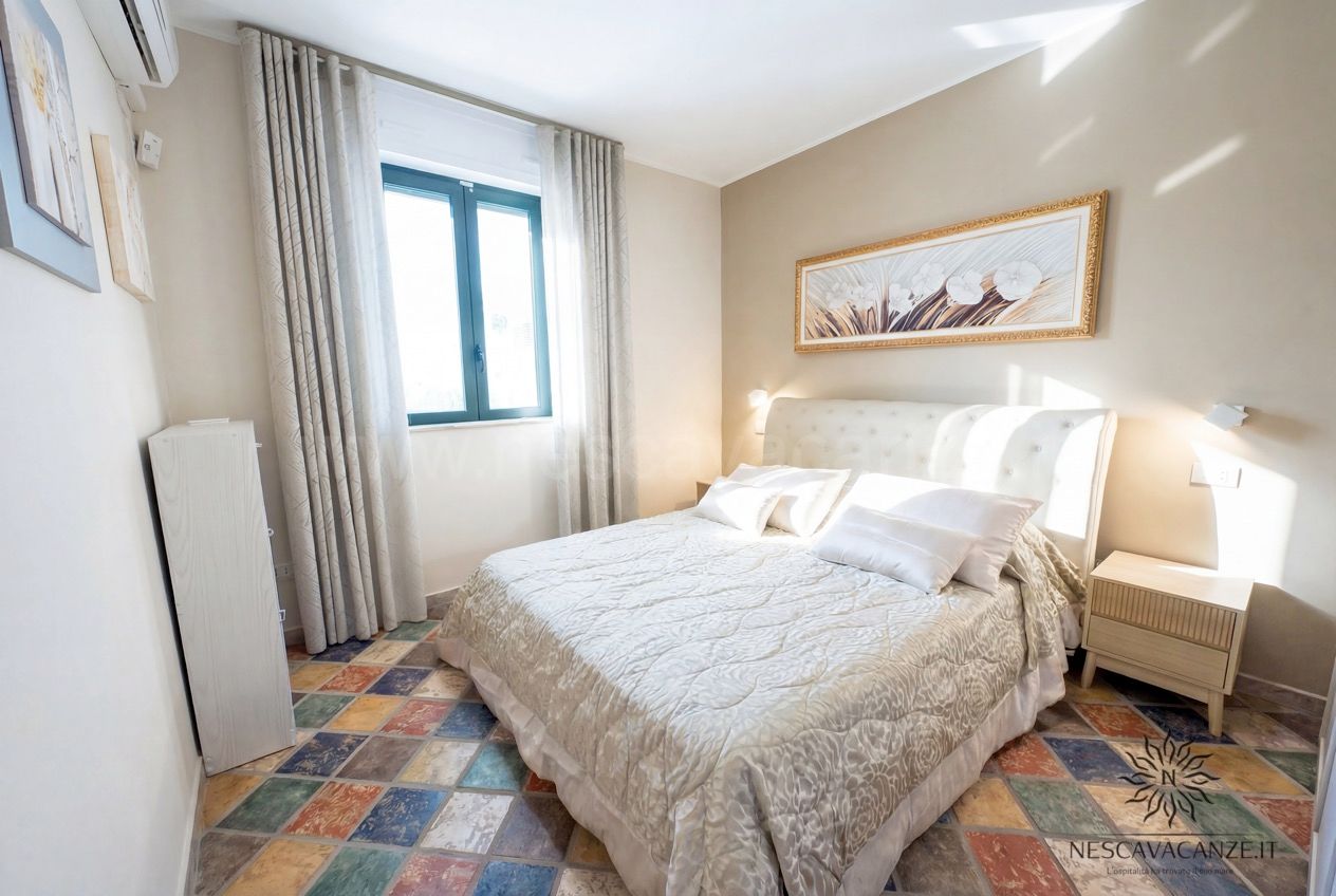 Casa Sabbia Oro - camera con letto matrimoniale, testiera capitonné, comodino e quadro sopra il letto