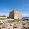 La torre di Torre Santa Sabina sugli scogli, con il mare alle spalle