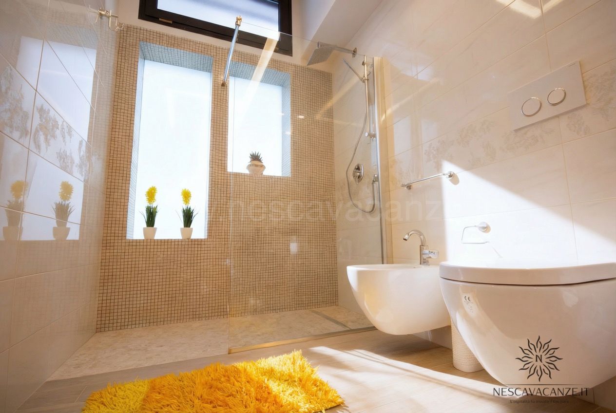 Casa Salento - bagno con ampia doccia a mosaico, wc e bidet sospesi e tappeto giallo