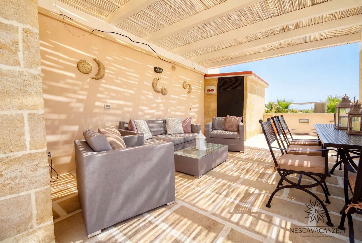 Casa Pescoluse 4 - terrazza con pergolato, divano angolare grigio, poltrona e lune decorative