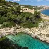La Cala dell'Acquaviva dall'alto, tra la macchia e la scogliera, con l'acqua verde e chiara