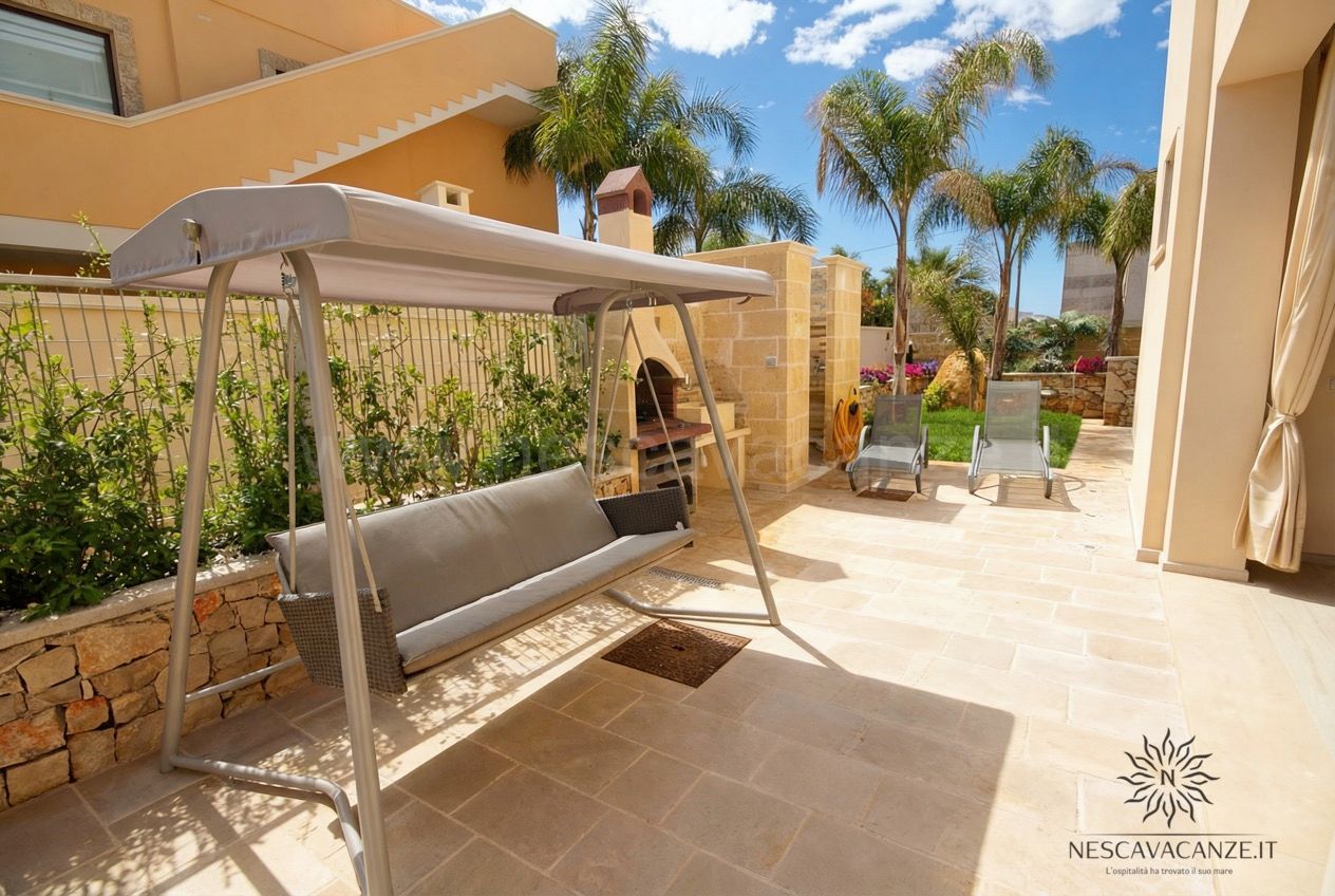 Casa Salento - patio in pietra con dondolo, barbecue in muratura, lettini e palme sotto il cielo
