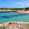 Caletta di sabbia e acqua turchese a Costa Merlata