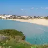La baia di Montedarena: spiaggia di sabbia chiara ad arco e acqua turchese bassa