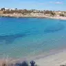 La baia di Saturo con l'acqua turchese e le case sul basso promontorio