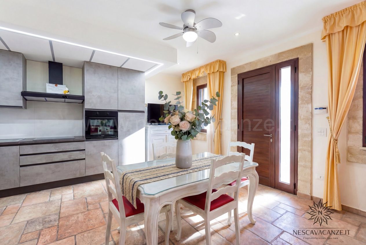 Casa Pescoluse 5 - cucina moderna grigia con forno e tavolo da pranzo con rose