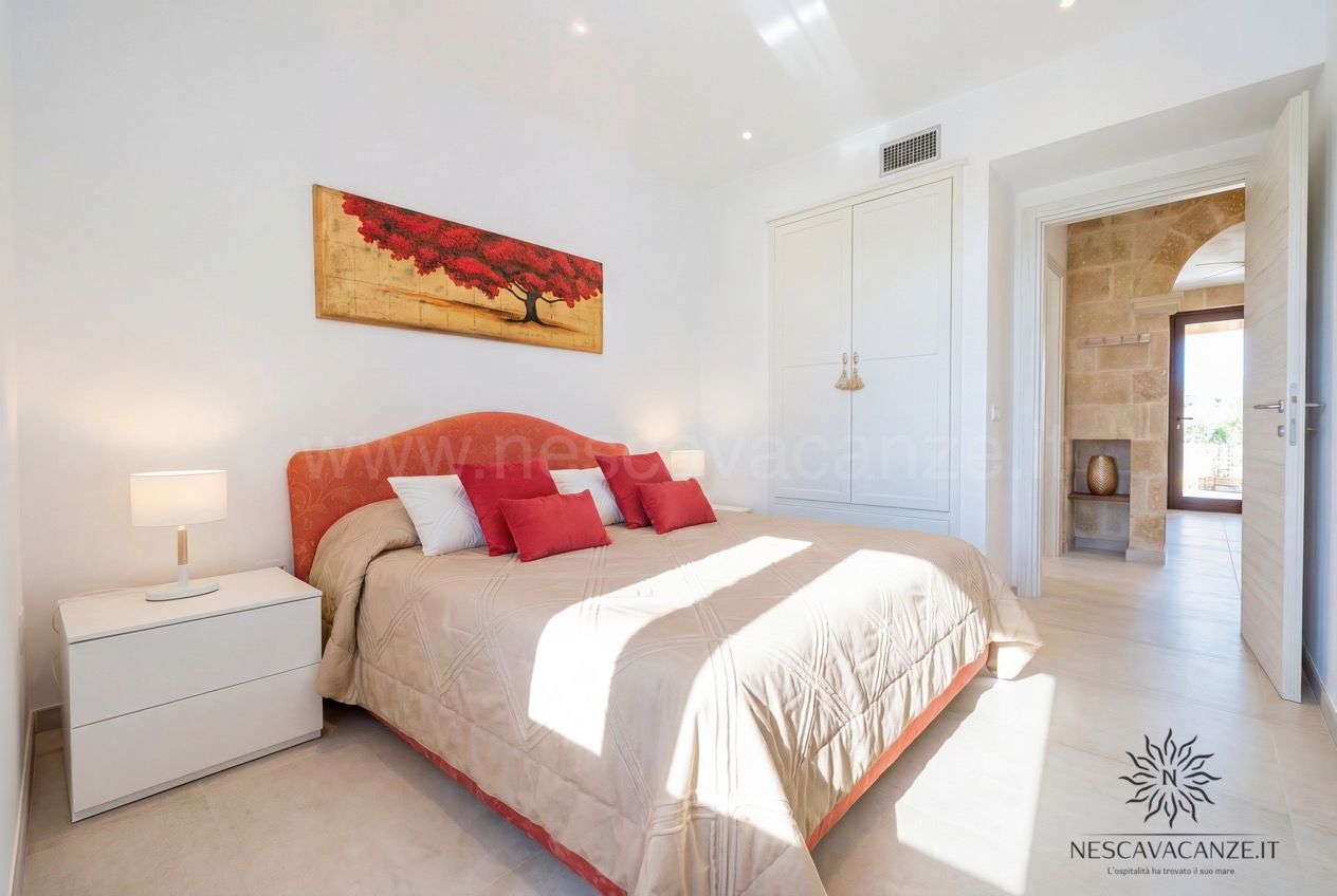 Casa Pescoluse 1 - camera matrimoniale con testiera rossa, armadio bianco e comodino