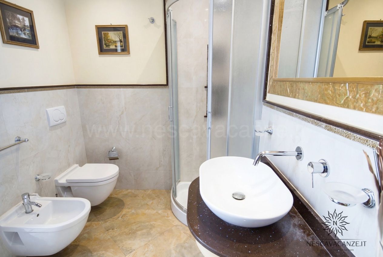 Casa Pescoluse 9 - bagno completo con wc, bidet, doccia angolare e lavabo su piano scuro