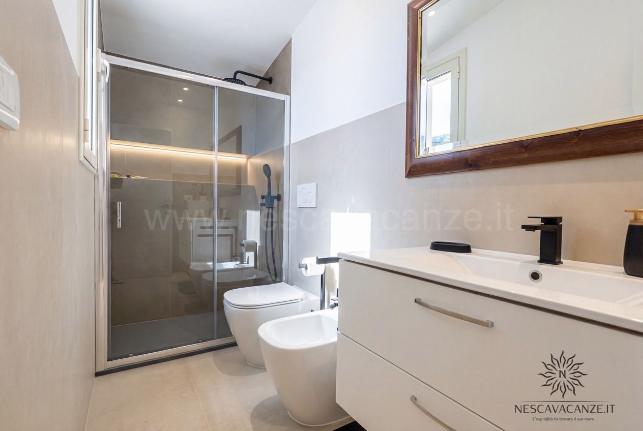 Casa Pescoluse 2 - bagno con doccia in vetro, wc, bidet, mobile bianco e specchio in legno